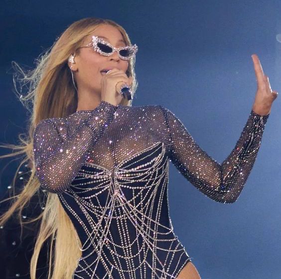 Beyonce on paris stop with glasses and single hand up